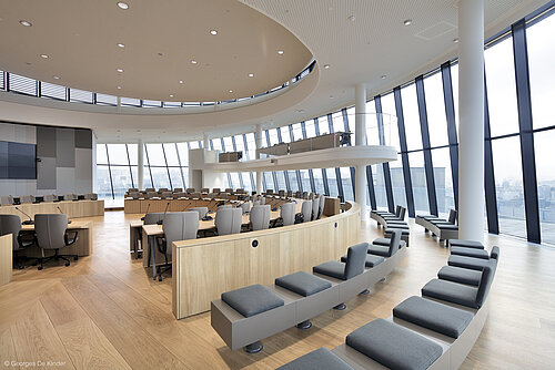 The photo shows gray Intra chairs arranged in circular rows. There is a microphone at each seat.