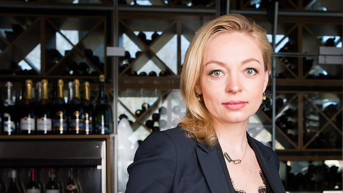 A portrait of a young businesswoman with blond hair.