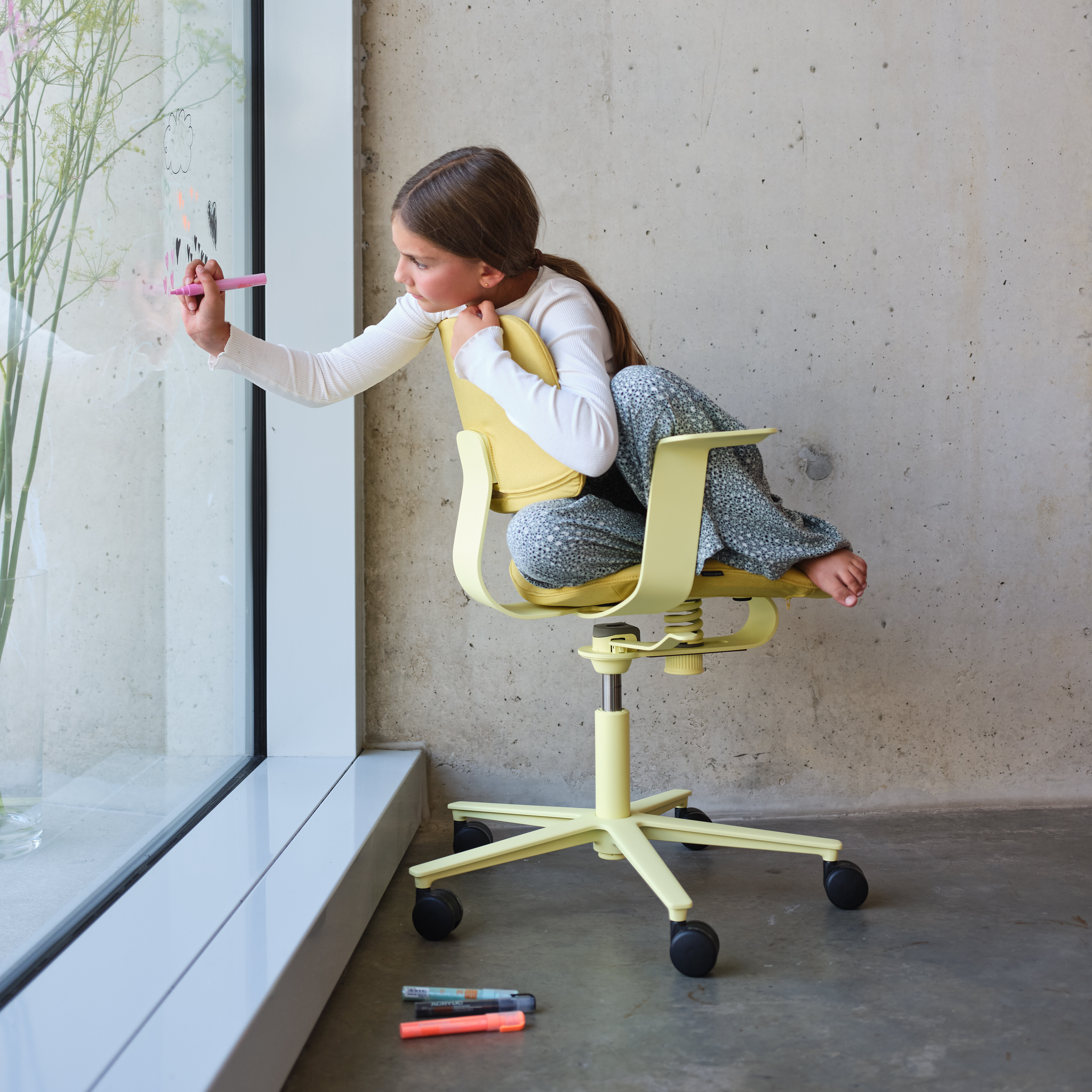 Wichair in modern interior by window, child drawing scene