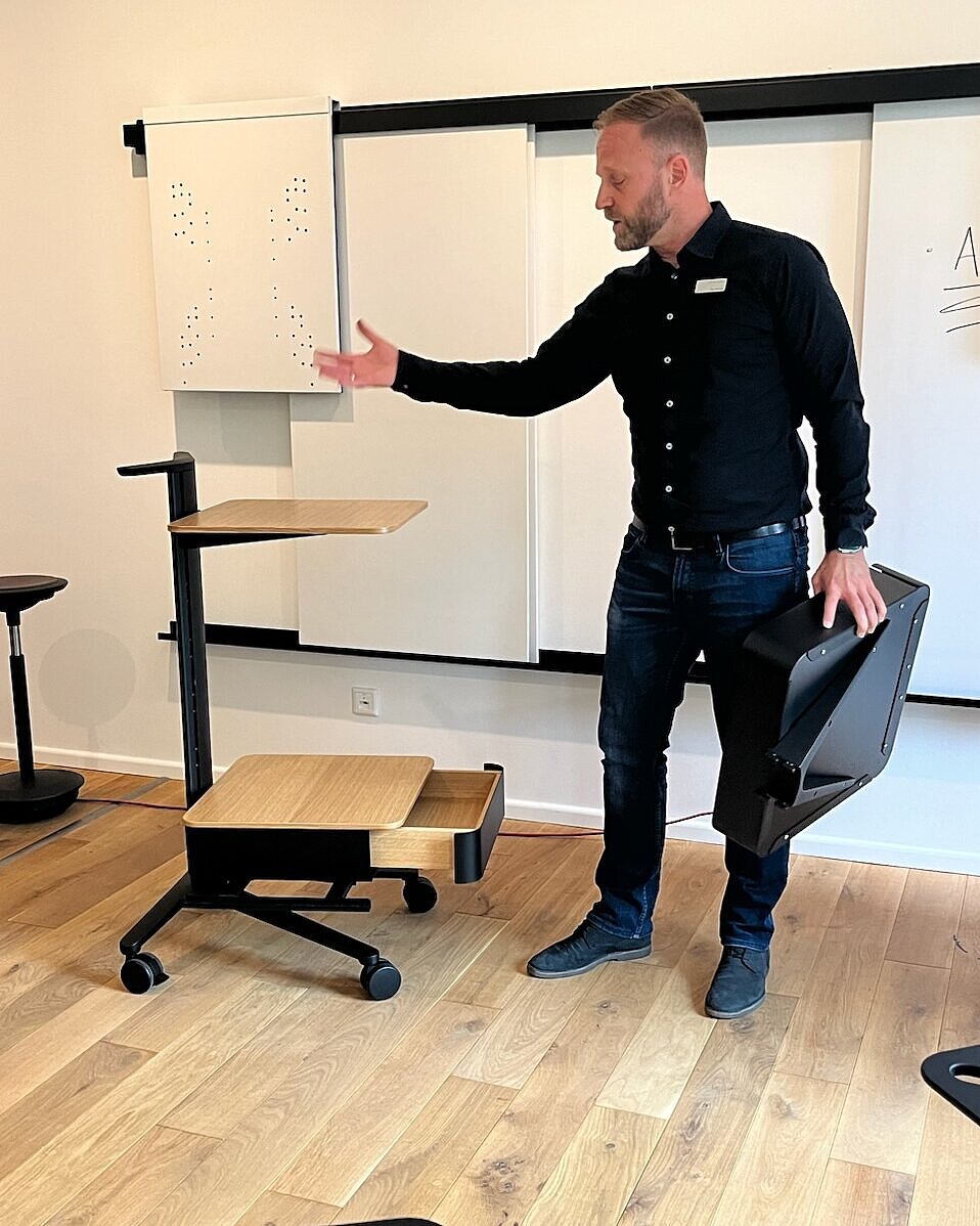 Tim Nenast demonstrates the features of the Confair Next server rack. He is standing in front of a wall with several white Liteboards hanging on it.