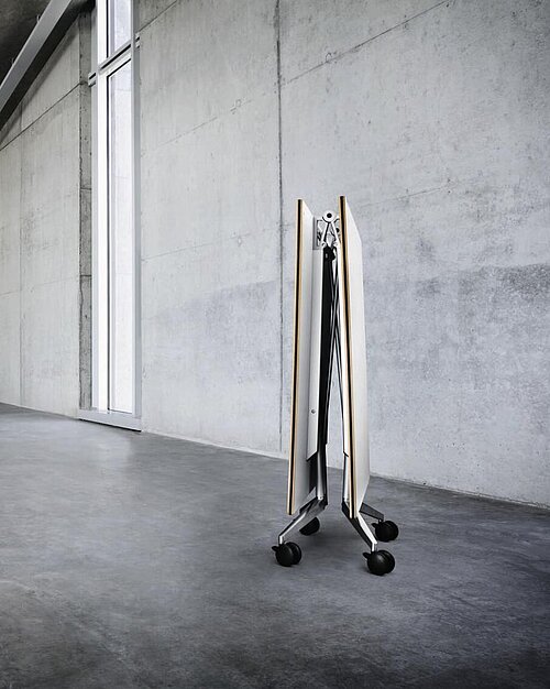 Confair folding tables stored upright in empty concrete workspace