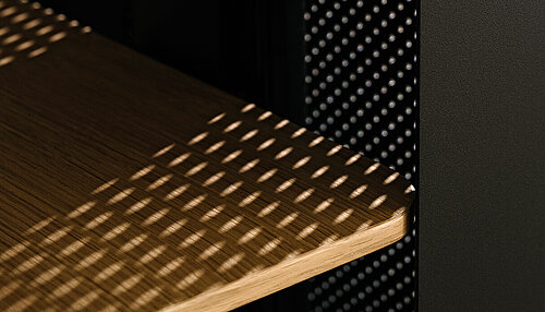 Confair Next lectern detail, close-up of perforated panel and wooden shelves