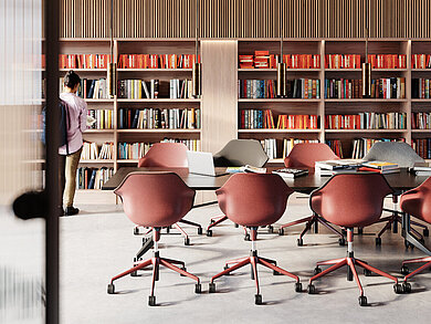 The bright library or study room is furnished with several Yonda chairs, shown here in warm shades of red and gray. The chairs blend seamlessly into the modern work environment and offer freedom of movement as well as exceptional comfort. The color-coordinated furnishings create an inspiring atmosphere for learning and working.