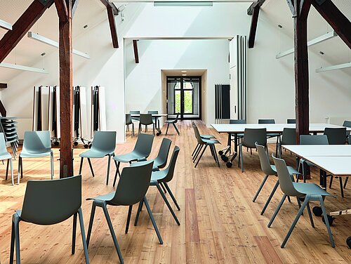 Aula chairs in spacious loft-style meeting room with flexible table setup