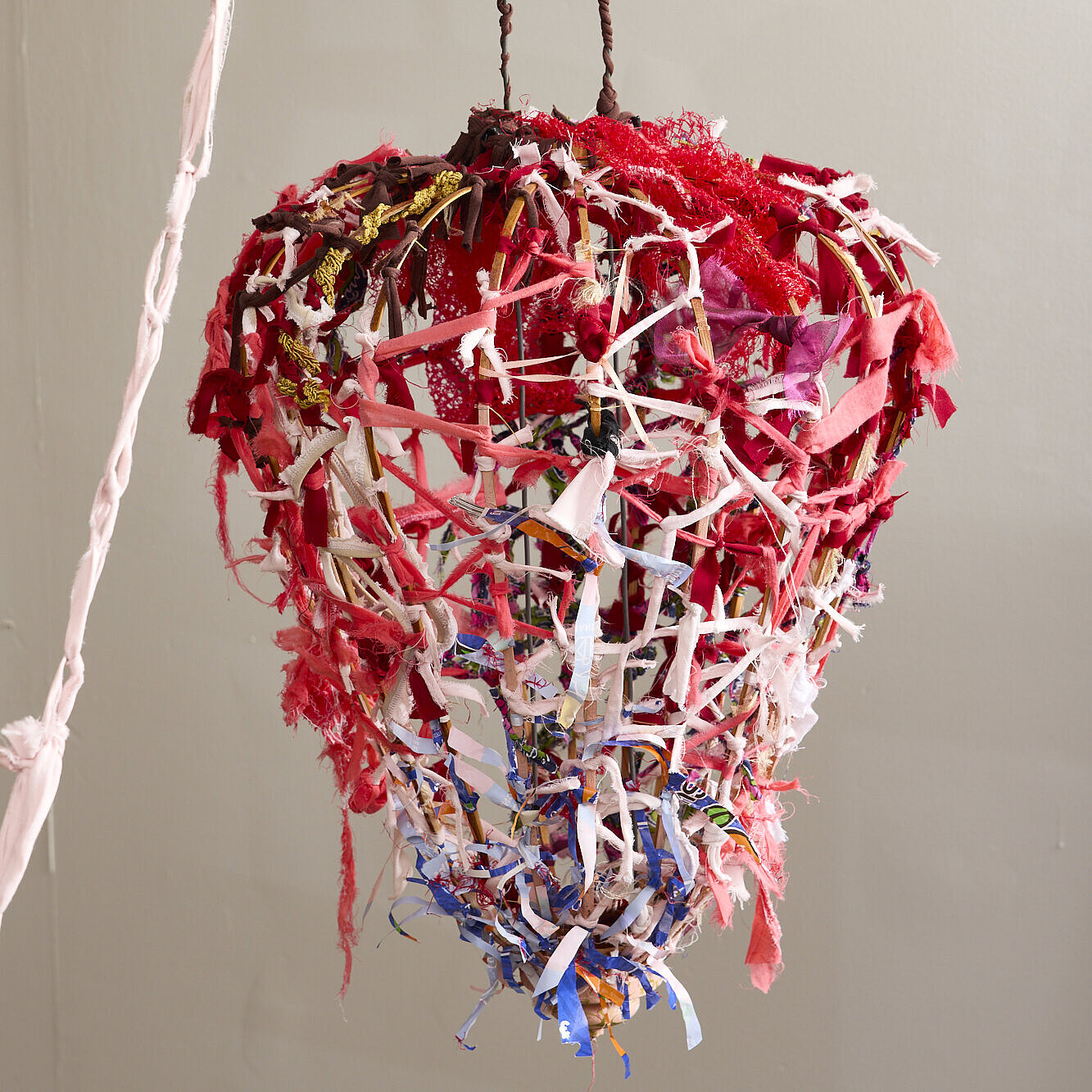 It's made from a braid of plastic scraps. The top part is red, then it turns white, and the tip at the bottom is blue.