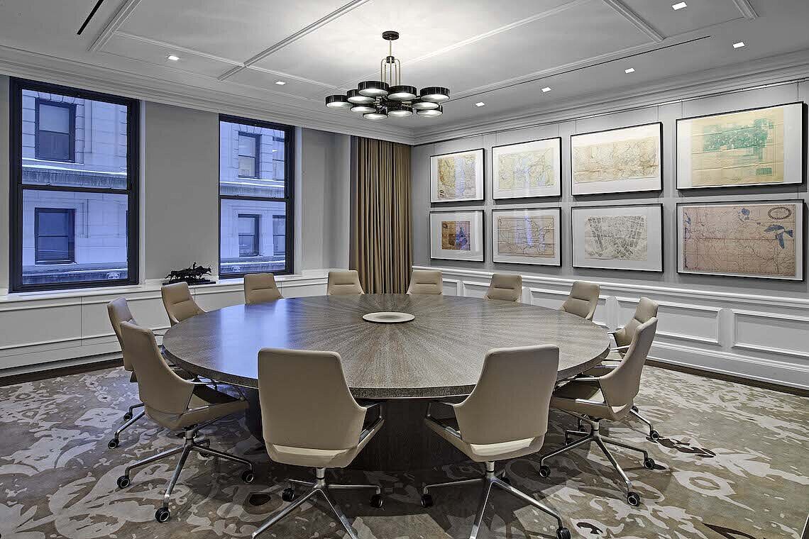 A conference room with a round table and light gray Graph chairs with low backrests.