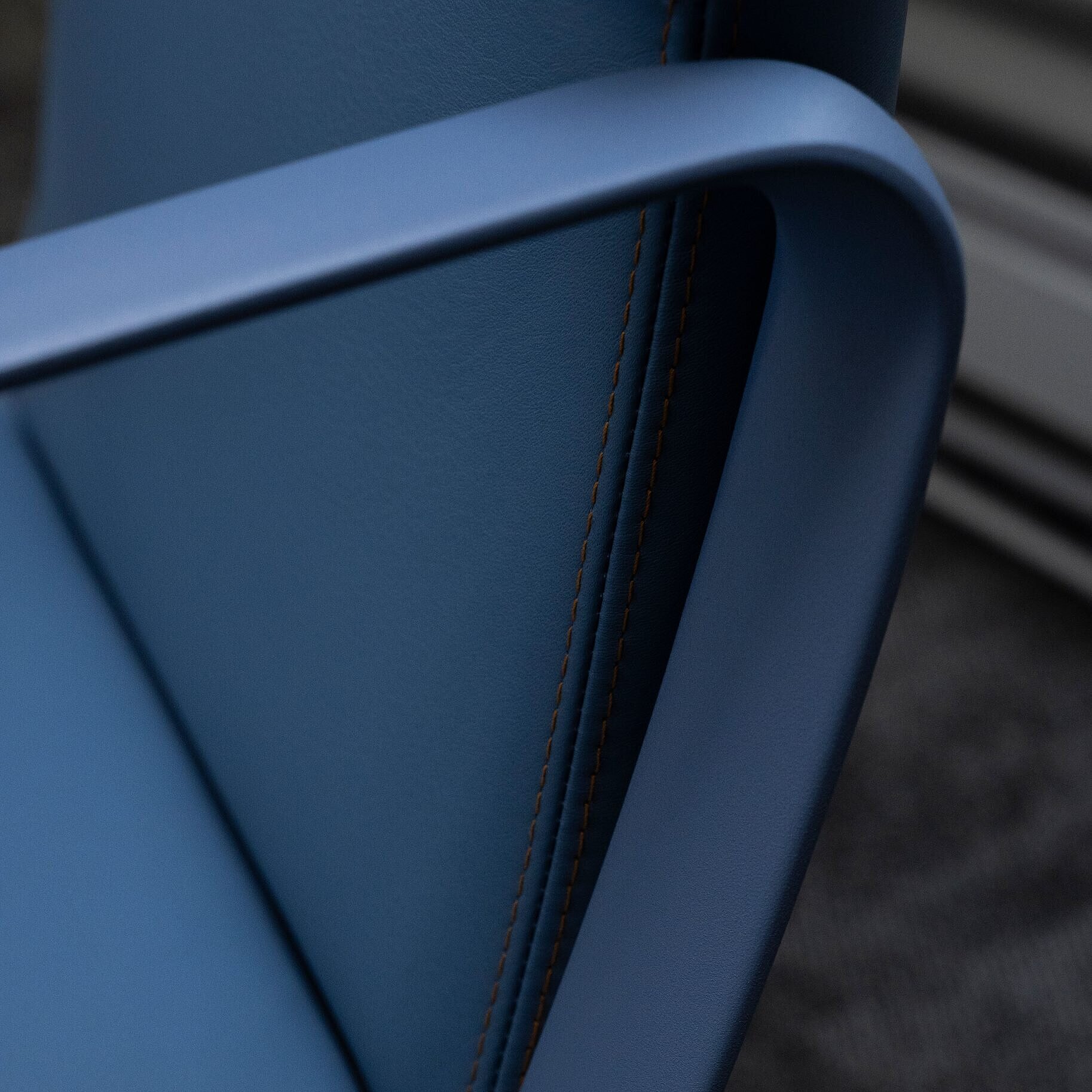 A close-up of an Intra chair with blue leather. The focus is on the blue ring armrest.