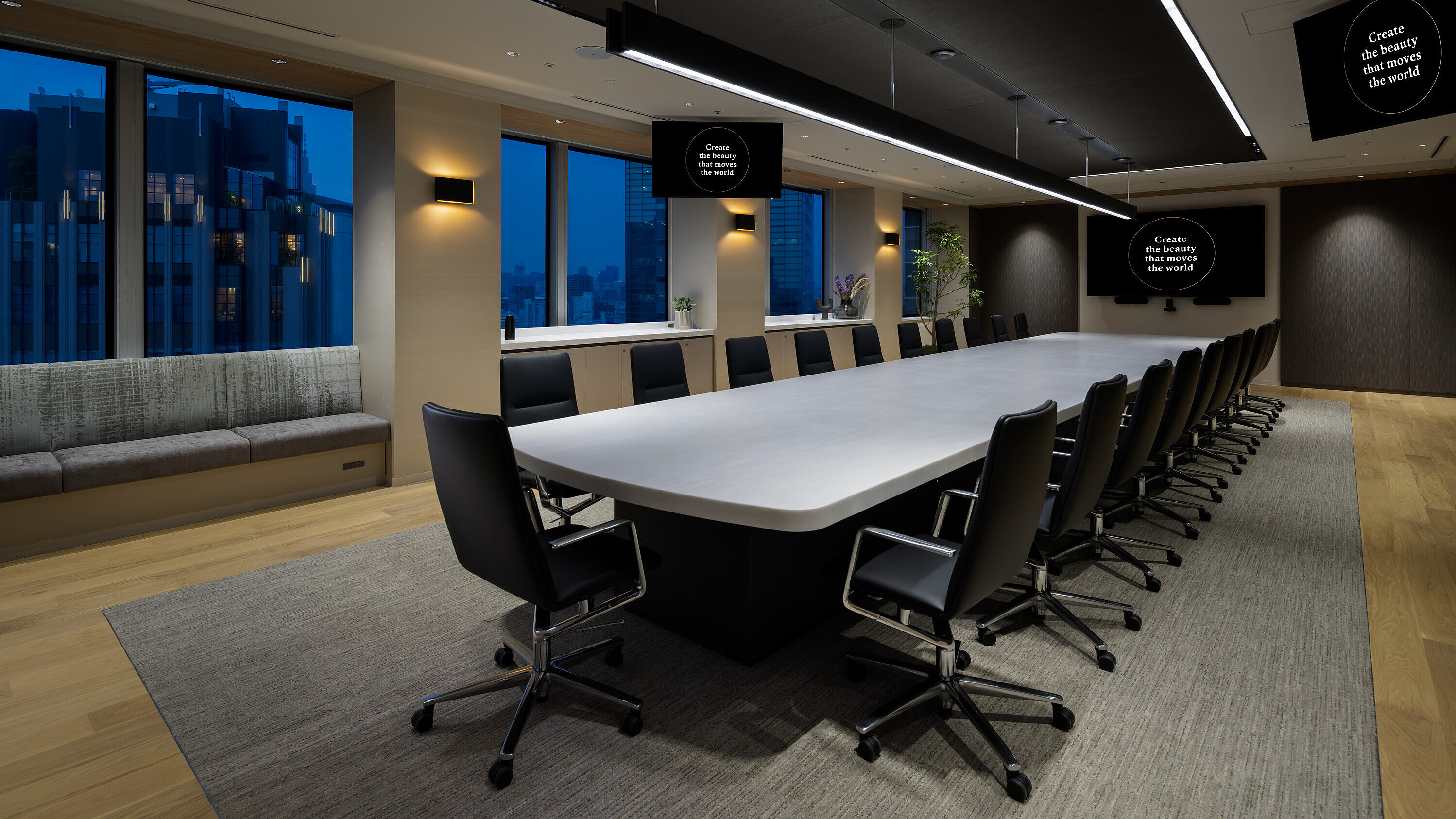 In a large conference room, several Sola conference chairs upholstered in black leather are arranged around a long table with a white tabletop.