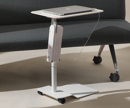 Confair Next side table on casters next to sofa, mobile workstation scene