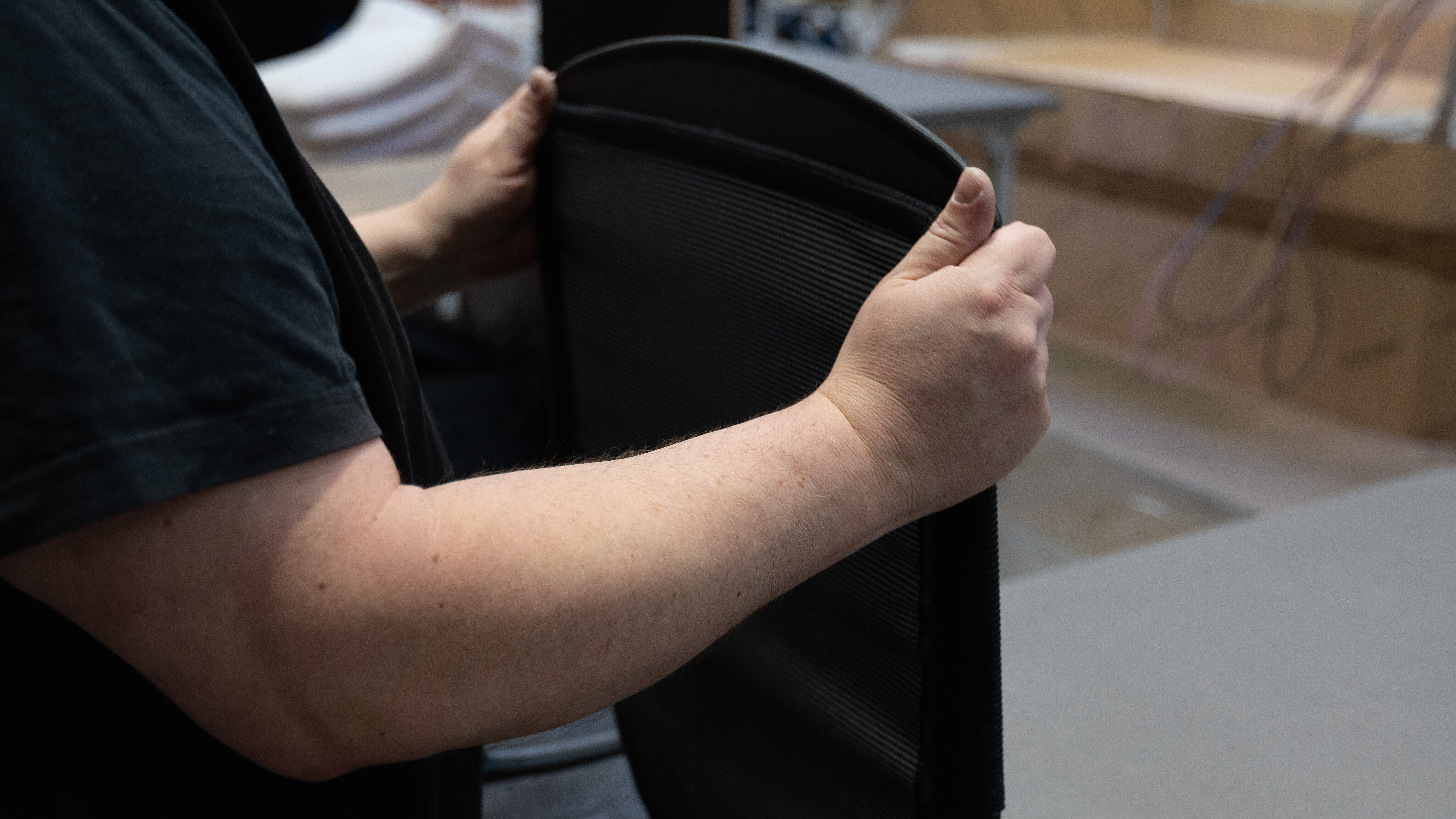A close-up of someone pulling the mesh backing from the modus onto the back frame.