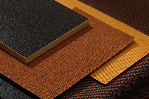 This material set features surfaces in black, terracotta, bronze, and yellow, combined with textiles and wood patterns. The arrangement conveys a warm, elegant, and high-quality design aesthetic.