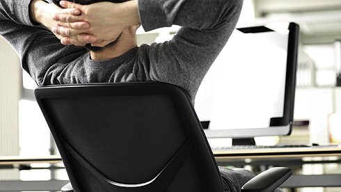 IN-Swivel-Chair in office workspace, user leaning back at desk