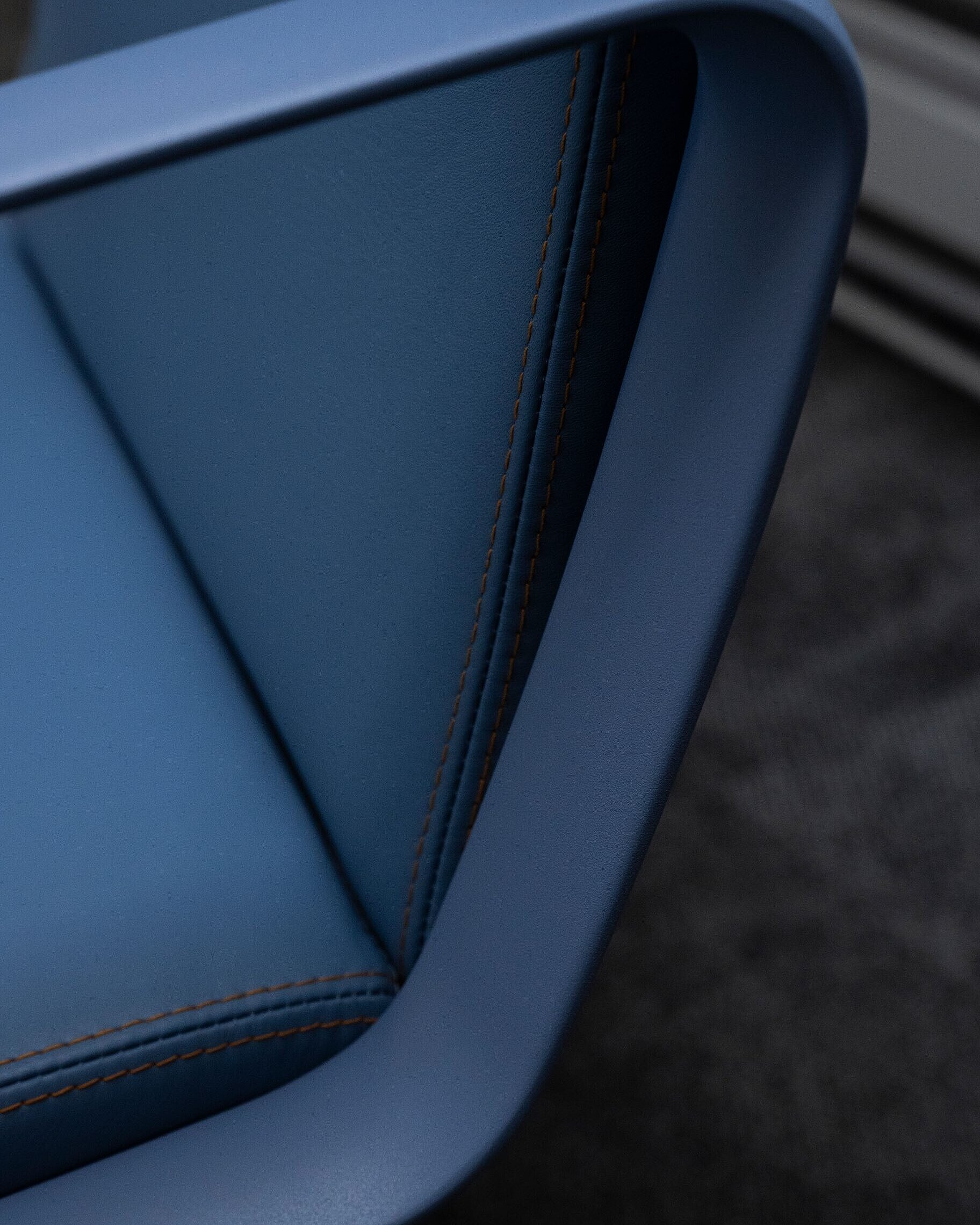 A close-up of an Intra chair with blue leather. The focus is on the blue ring armrest.
