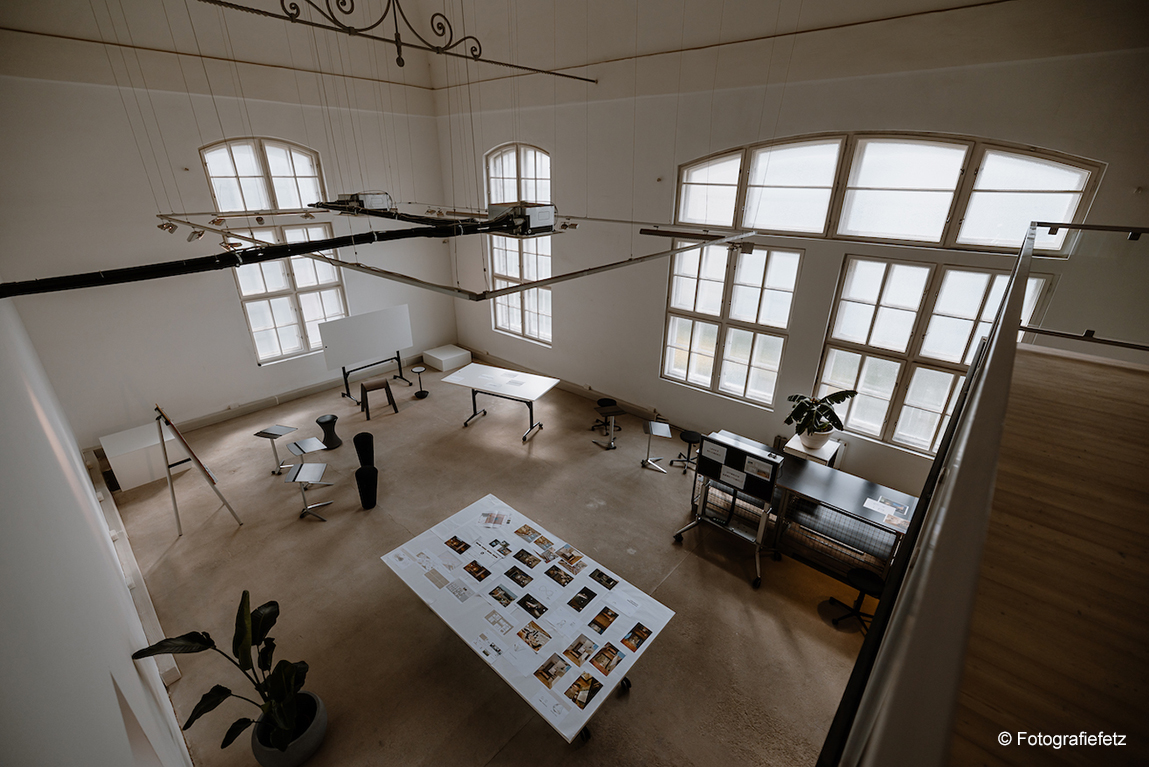 The room features several pieces of Wilkhahn furniture, including Timetable and Stand-Ups. The tables are white and the Stand-Ups are black. This is an example of a room where a workshop is taking place, so the furniture is not arranged in a fixed layout