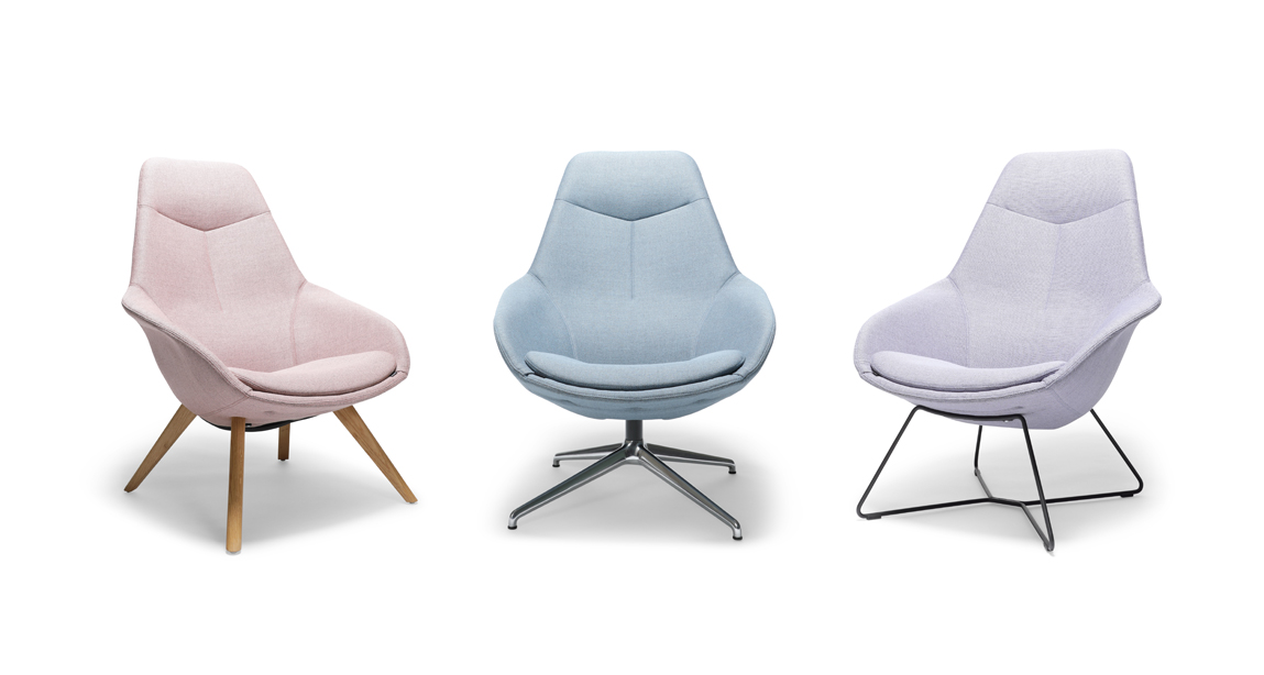 It is a photo with a white background showing three fully upholstered Yonda lounge chairs in three different colors: pastel pink, blue, and purple. The three chairs have different bases: a four-legged wooden base, a four-legged chrome base, and a cantilever base.