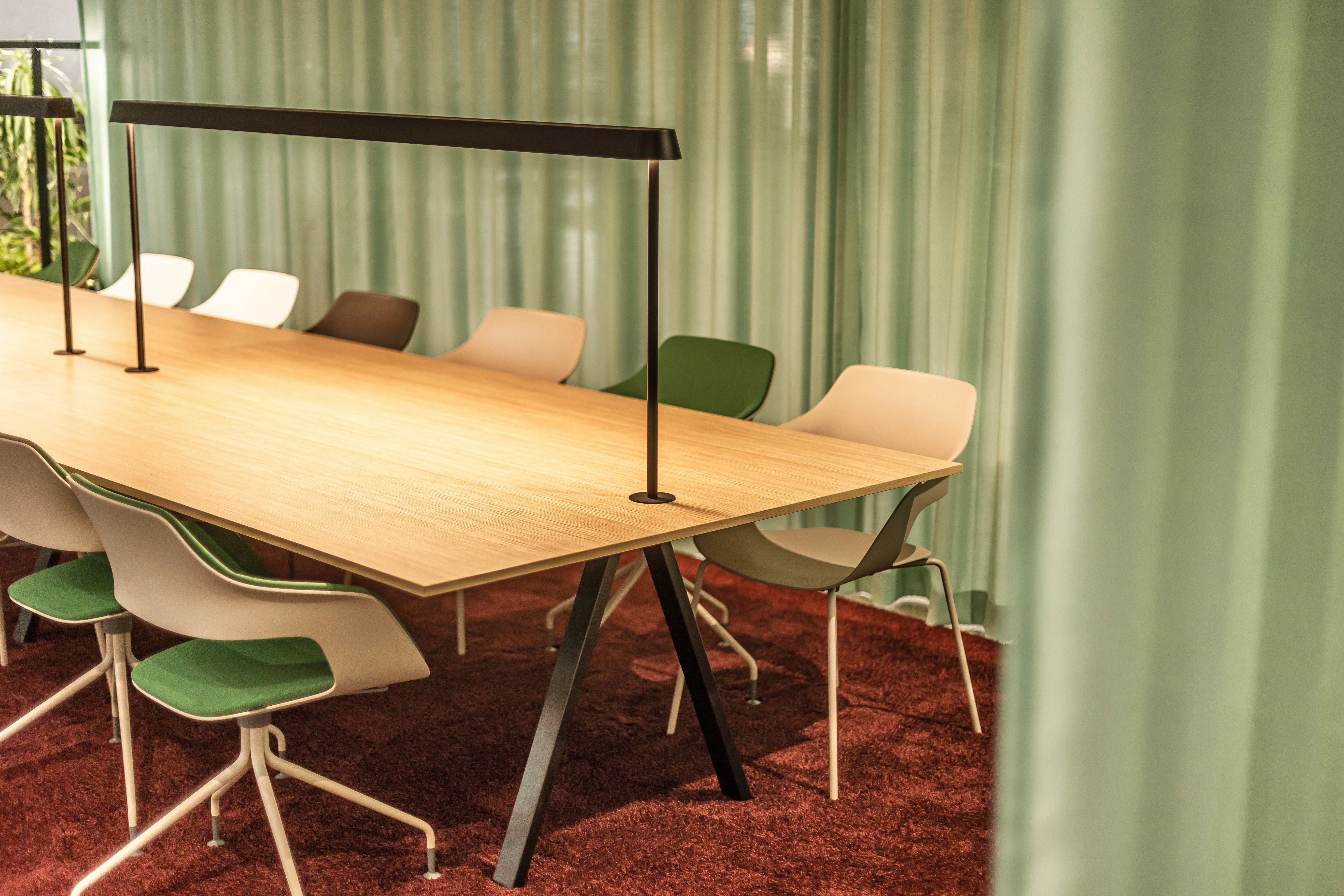 This is a close-up of a table setting with cream beige Occo chairs. The seat pads come in various colors, such as green, brown, and white. The whole scene is set against a light green curtain.